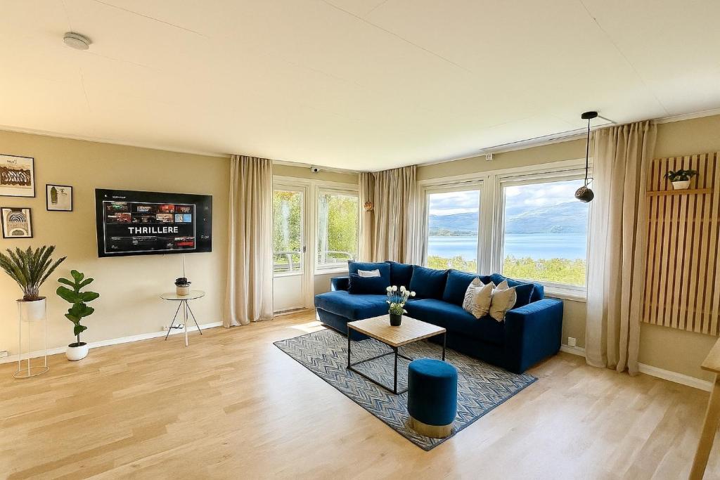 a living room with a blue couch and a tv at Top location - Amazing views in Tromsø