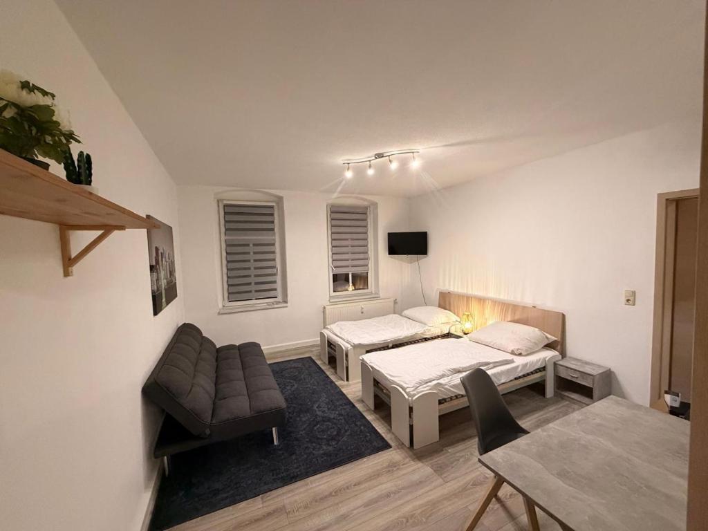 a living room with two beds and a table at Apartment DENISA in Gera