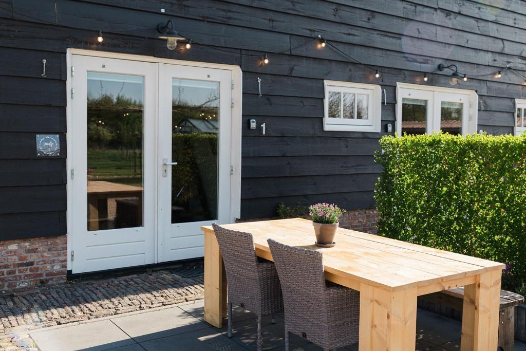 een houten tafel en stoelen voor een huis bij Hof Driewegen in Driewegen