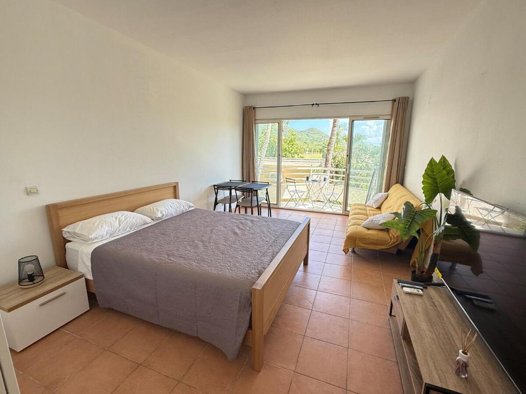 a bedroom with a bed and a living room at Cozy Beachside Studio with Beach Access & Pool in Marigot