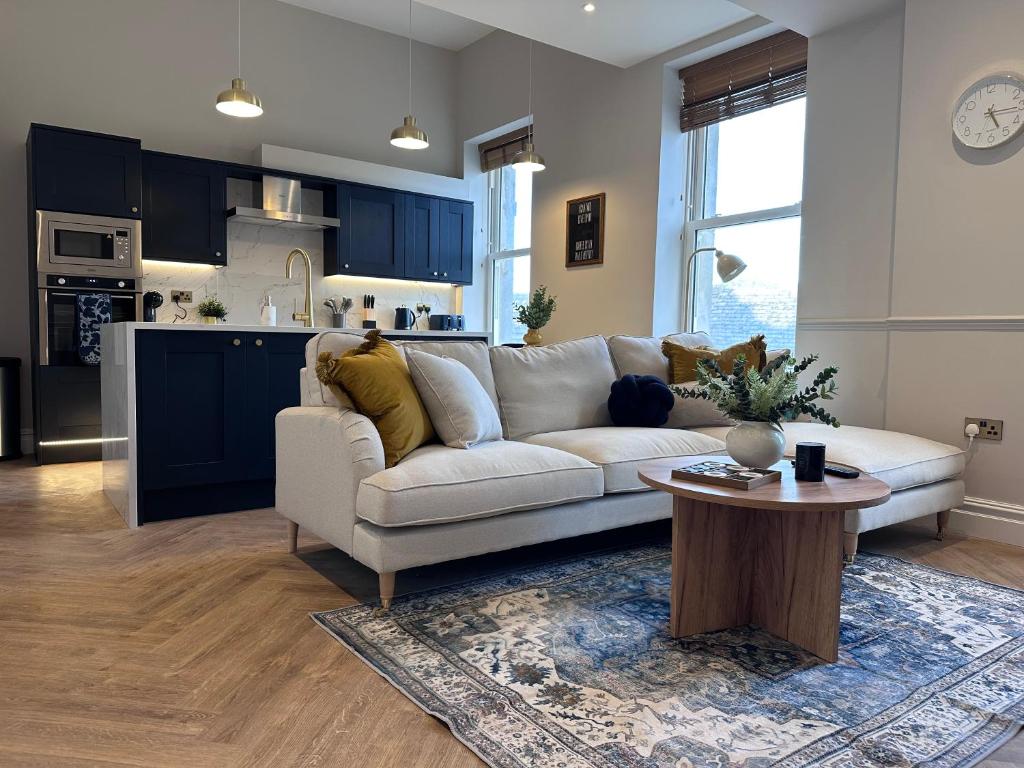 un salon avec un canapé blanc et une table dans l'établissement Luxury 2Bed 2 Bath Apartment in Historic Bank, à Leyburn