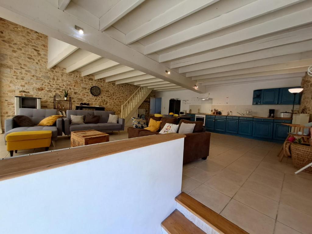 Saint-GoursonにあるLa grange Marieの青いキャビネットとレンガの壁がある広いリビングルーム