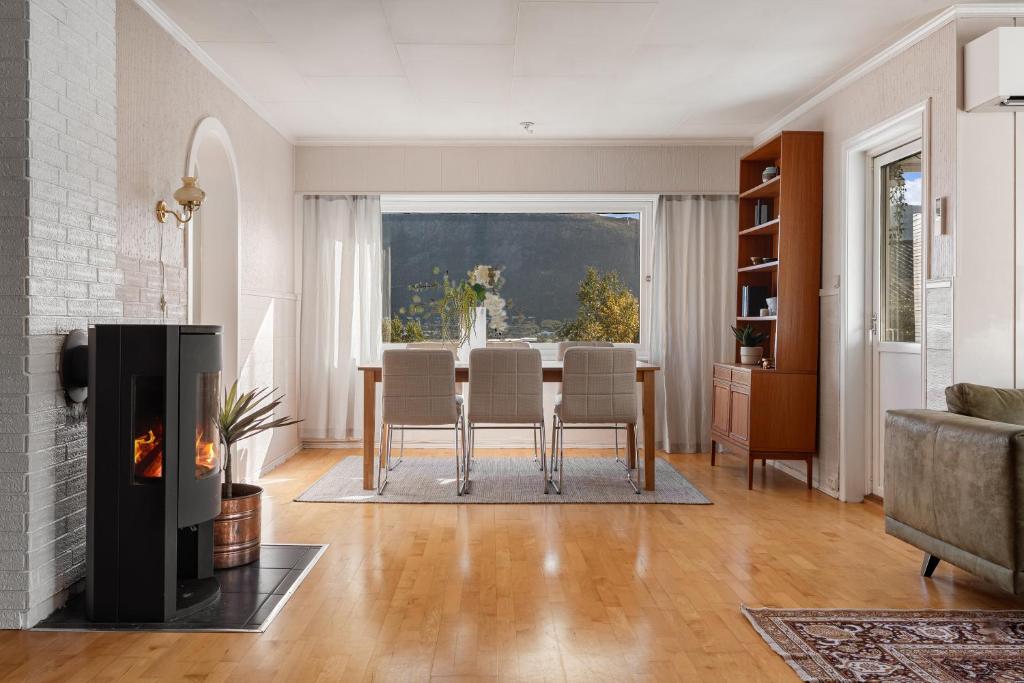 a living room with a table and a fireplace at Basecamp Dramsvegen Aurora Viewpoint in Tromsø