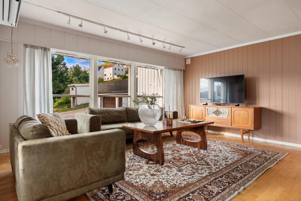 特罗姆瑟Basecamp Dramsvegen Aurora Viewpoint的客厅里有一张沙发和一张桌子。