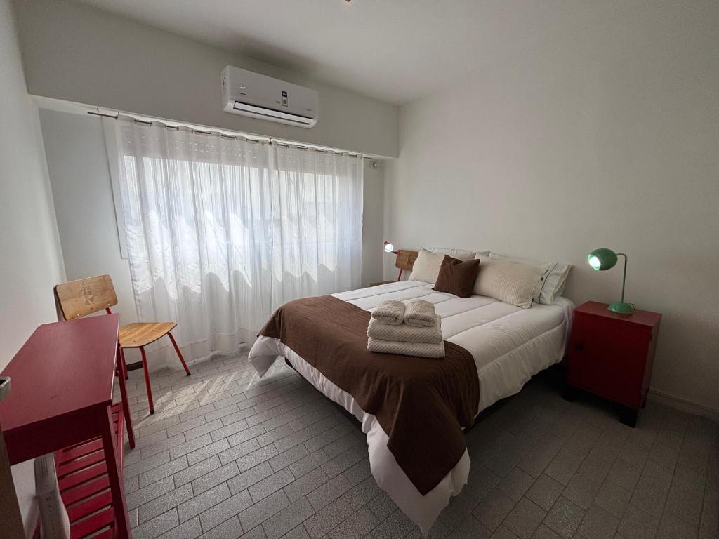 a bedroom with a large bed and a window at Minisuite Estación Ramos Mejía in Ramos Mejía