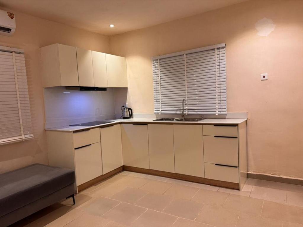 a small kitchen with white cabinets and a sink at One Bedroom Studio Apartment in Benin City