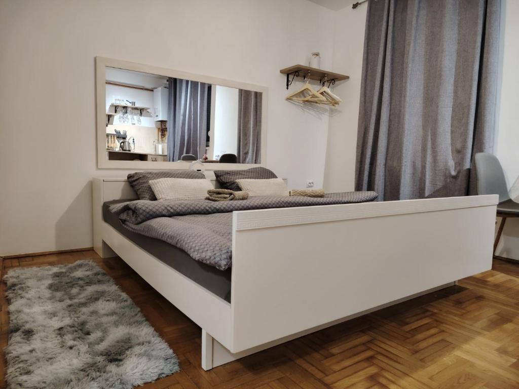 a white bed in a room with a mirror at River stay in Sremska Mitrovica