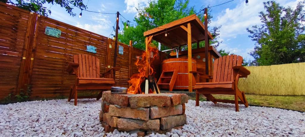 ein Spielplatz mit zwei Stühlen und einer Feuerstelle in der Unterkunft Cozy - Private Hot Tub & Garden - Fire Pit - Pet Friendly in Hajdúszoboszló