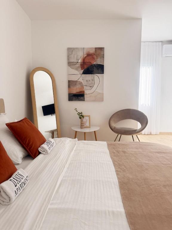 a bedroom with a large white bed and a chair at Danin apartmani in Bar