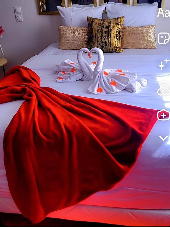 two swans made out of towels on a bed at La Cachette Fleurie in Hésingue