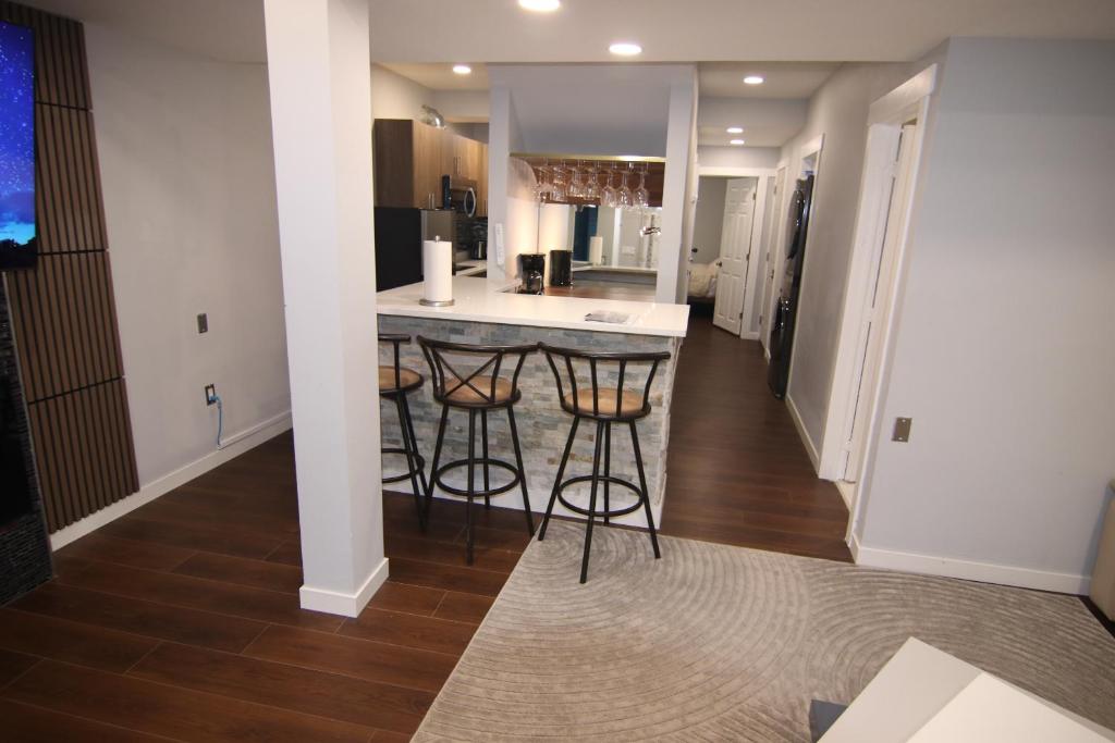 a kitchen with a counter and bar stools at beautiful private house in Edmonton