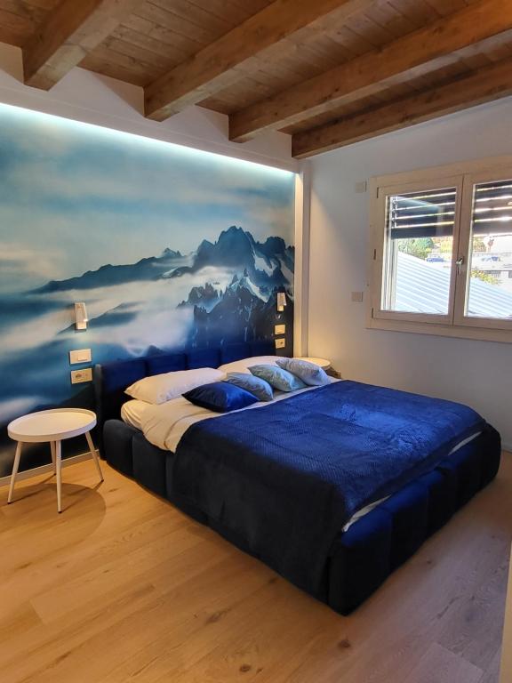 ein Schlafzimmer mit einem großen Bett mit einem Gemälde an der Wand in der Unterkunft La Dimora del Monte Bianco in Aosta
