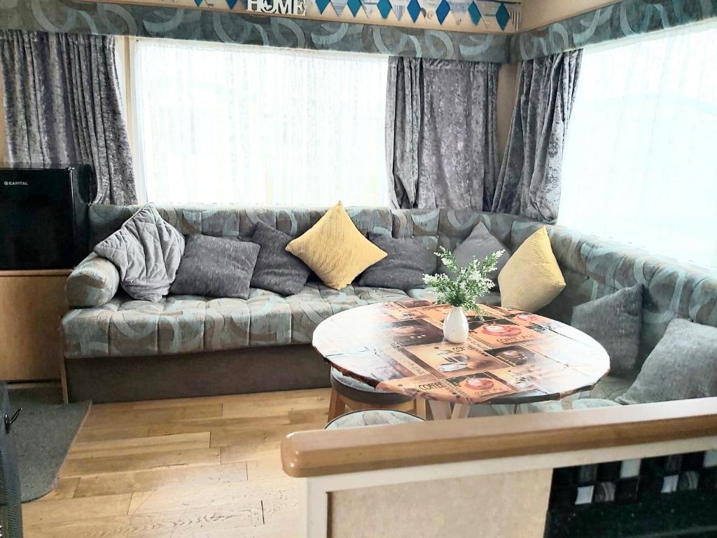 スケッグネスにあるE12 jeans caravan The Chaseのソファとテーブルのあるリビングルーム