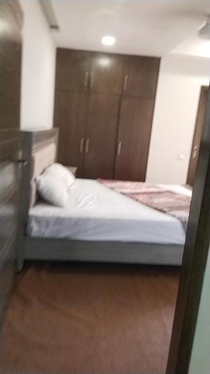 a bedroom with two beds and wooden cabinets at Afzal real estate builder's in Islamabad
