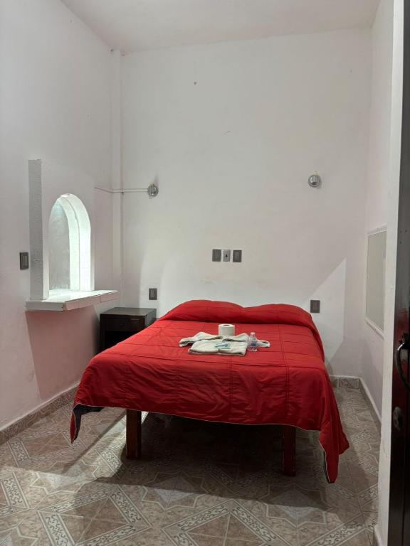 a bedroom with a red bed with a red blanket at Habitaciones Climar in Veracruz