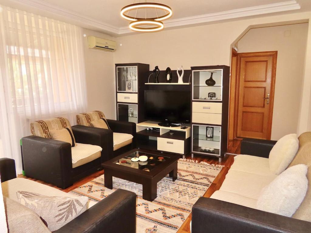a living room with couches and a flat screen tv at Chez Apartment in Prizren
