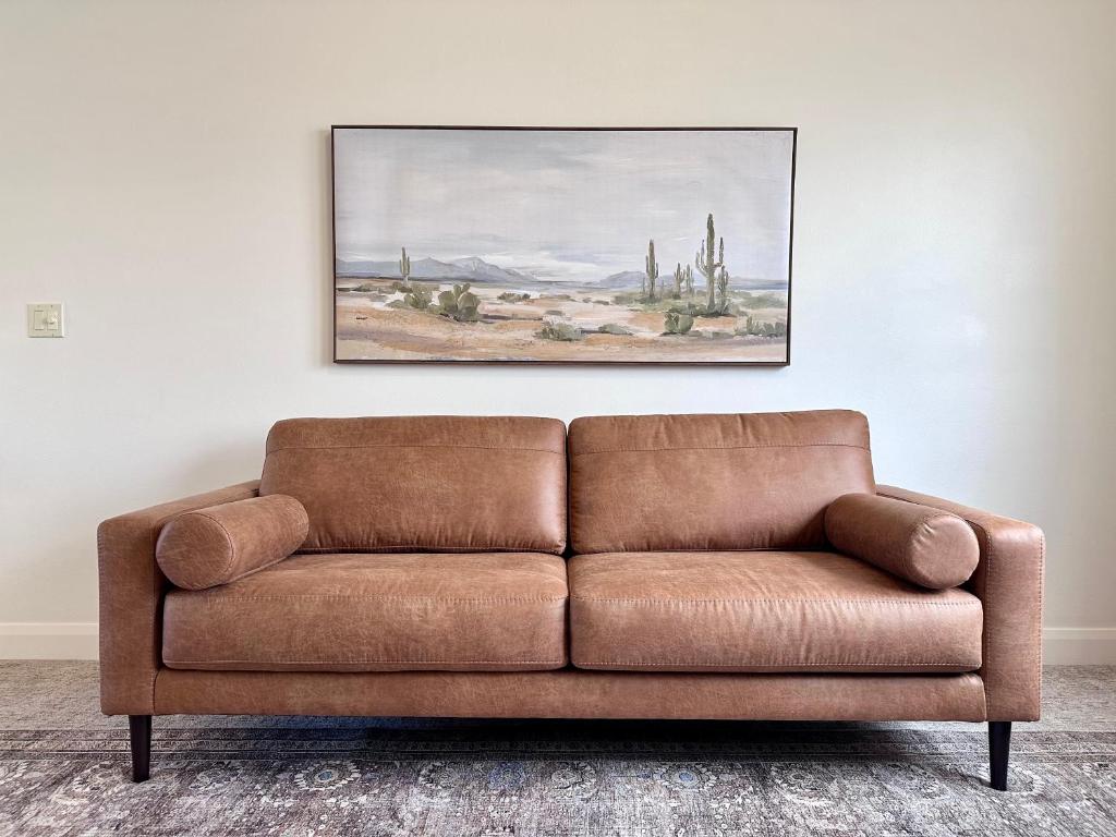 eine braune Couch in einem Wohnzimmer mit einem Gemälde an der Wand in der Unterkunft King Beds Full Kitchen Peaceful 2br Casita Re in Washington
