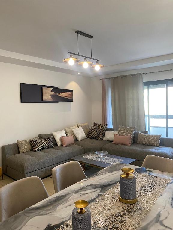 una sala de estar con un sofá y una mesa en Appartement lumineux à 5 minutes de la gare, en Casablanca