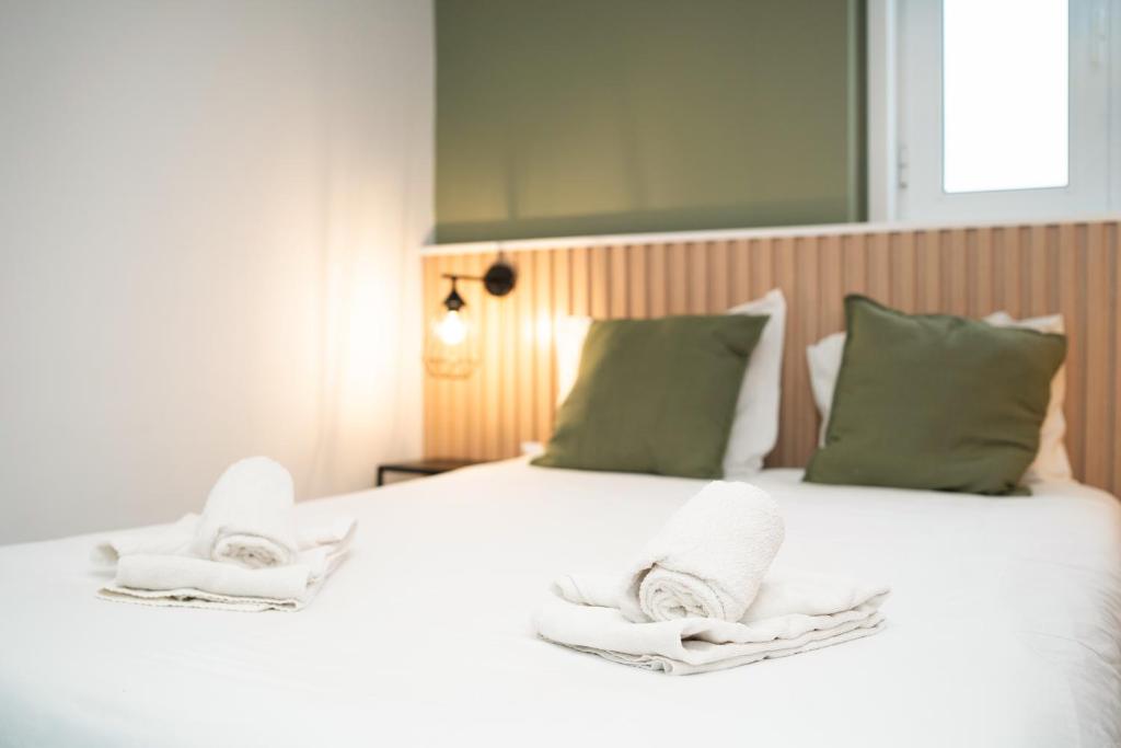a bedroom with a white bed with towels on it at Porto Panorama by Sira Stays in Porto