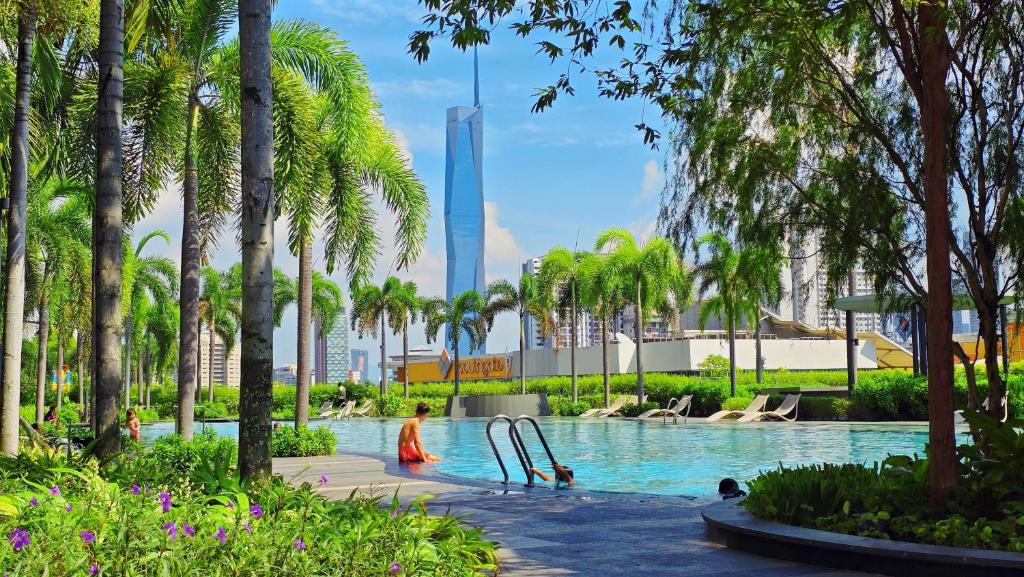 a swimming pool with palm trees and a slide at Trion Sky Suite KL in Kuala Lumpur