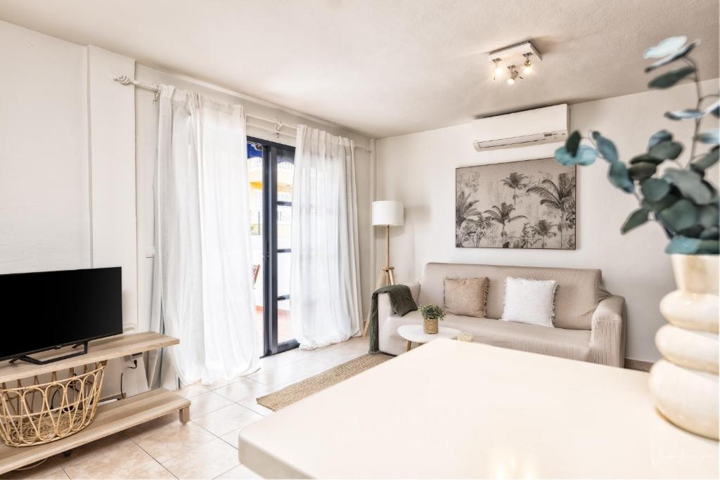 sala de estar con cama, TV y sofá en Marea, in the heart of the Atlantic, en Puerto Naos