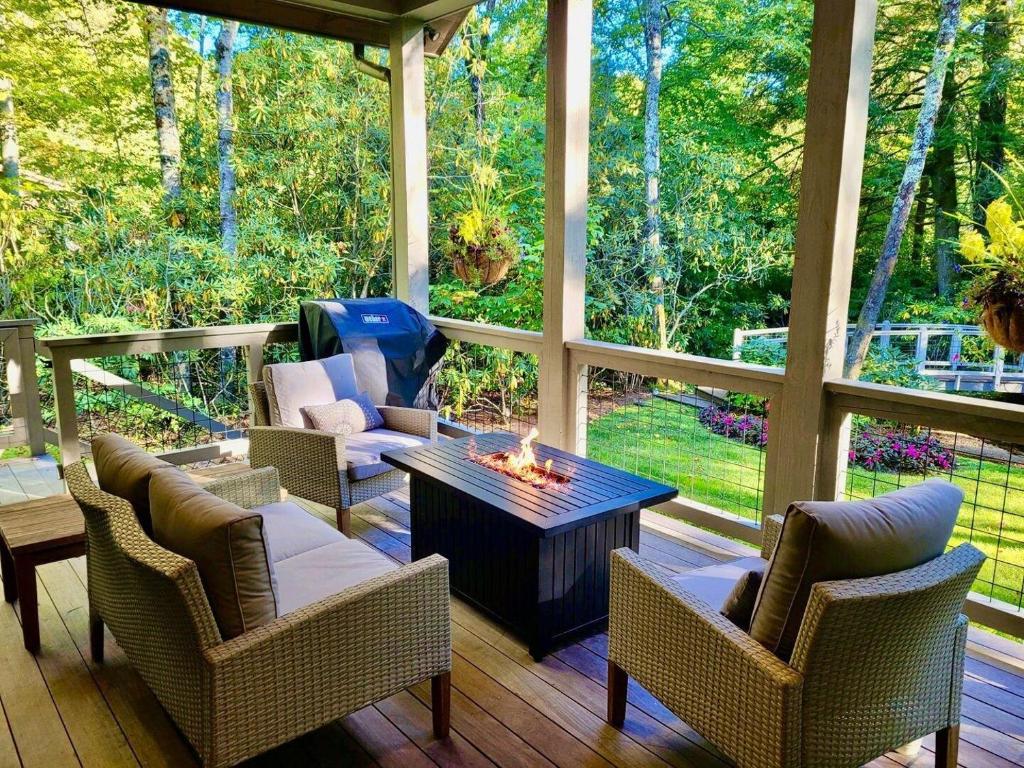 a screened in porch with chairs and a fireplace at Dancing Bear Walk to Town in Highlands