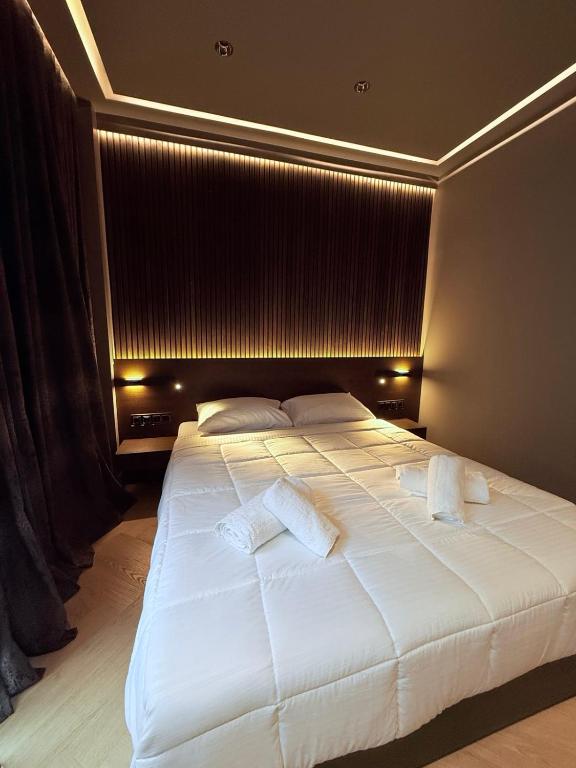 a bedroom with a large white bed with two pillows at Brown Velvet Thess in Thessaloniki