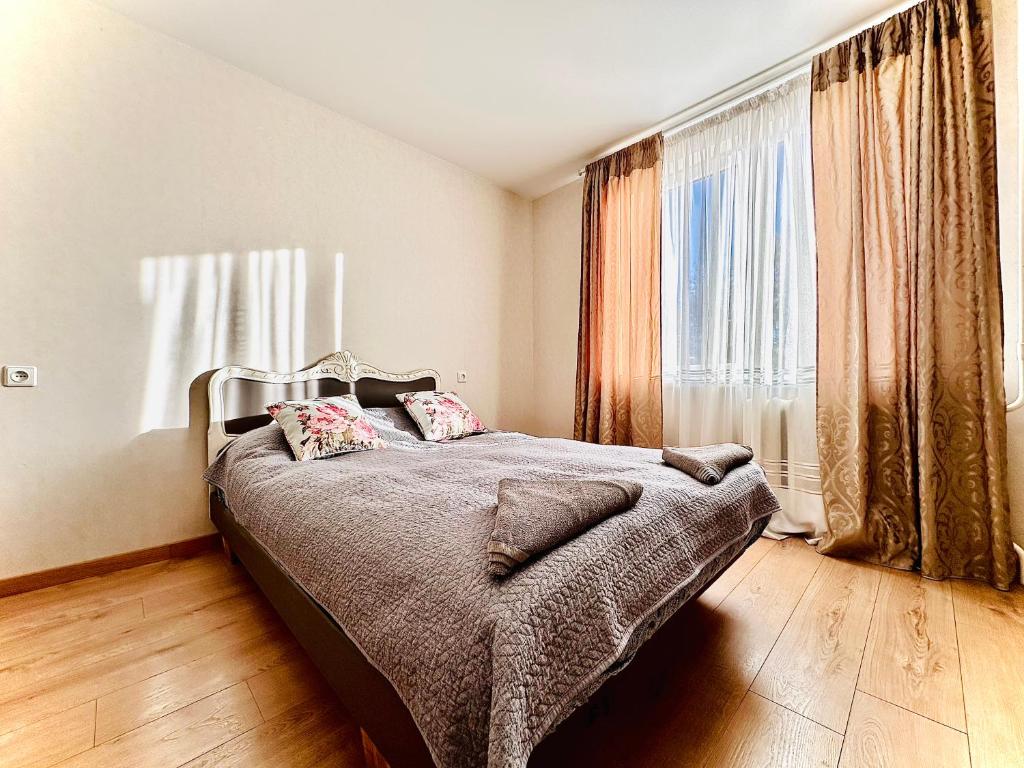 a bedroom with a bed and a large window at M&M Apartment VI SELF CHECK-IN in Panevėžys