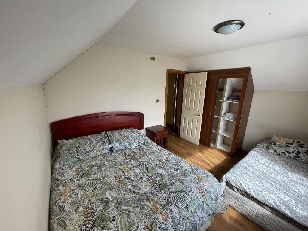 a bedroom with a bed and a closet with a door at Casa Rukalma Estación in Villarrica