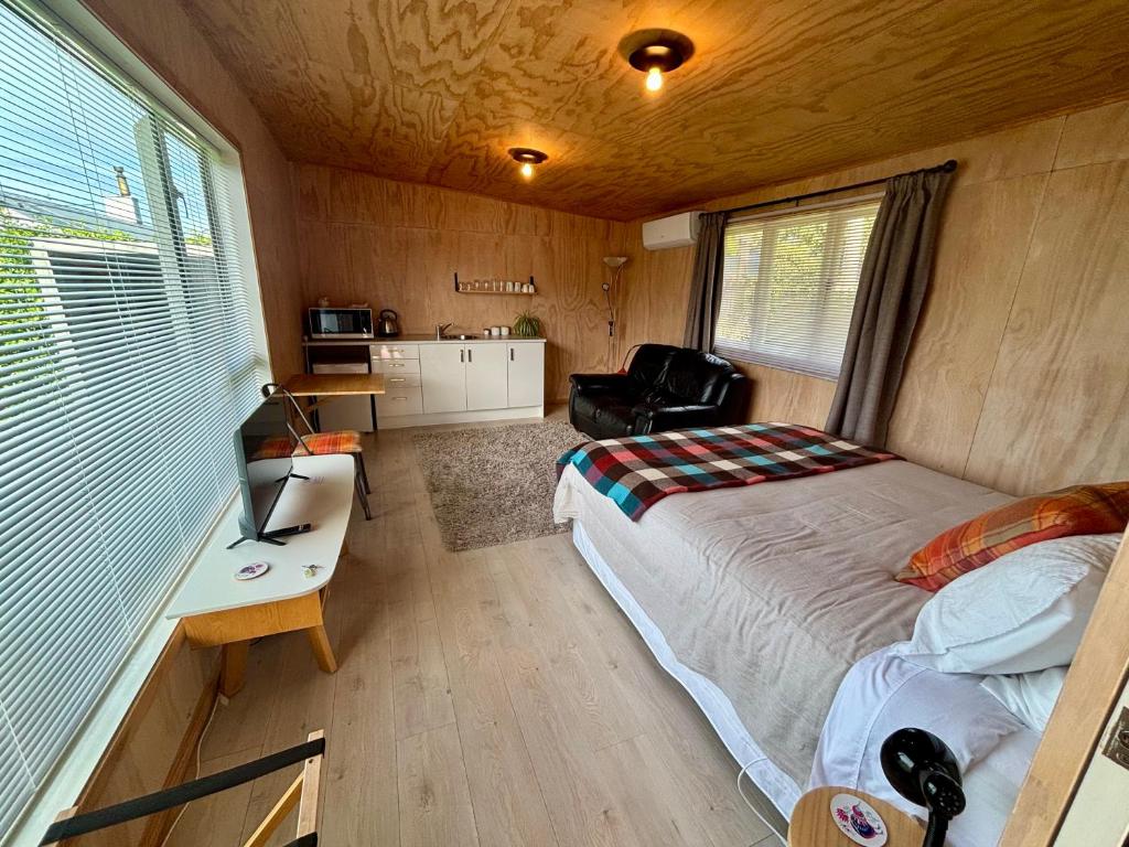 a bedroom with a bed and a desk in a room at Brighton Beach in Dunedin