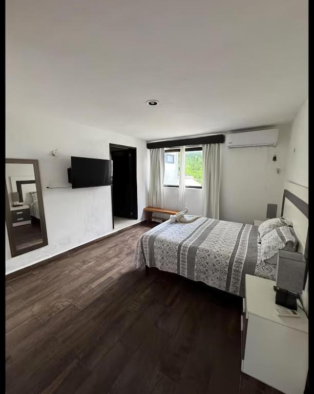 a bedroom with a bed and a desk and a mirror at Departamentos Naa'y in Valladolid