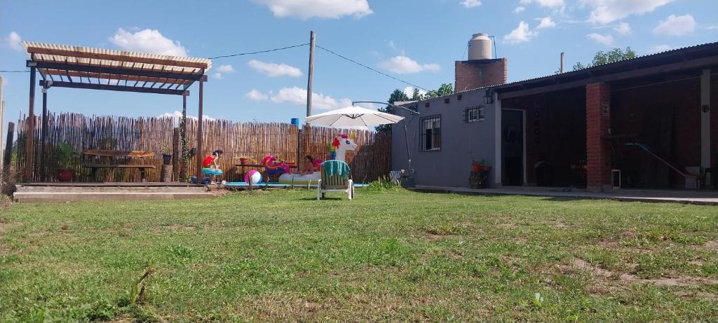 een tuin met een parasol en mensen die op een terras zitten bij Quincho Gala in El Cadillal