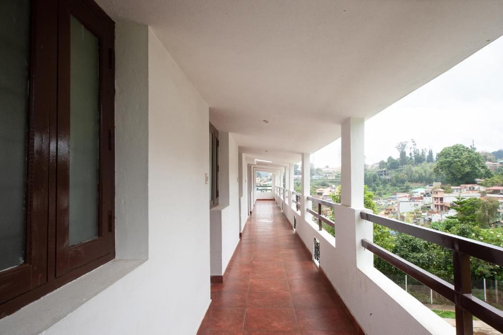a corridor of a building with a balcony at Hotel O RGP Residency Kodaikanal lake in Kodaikānāl
