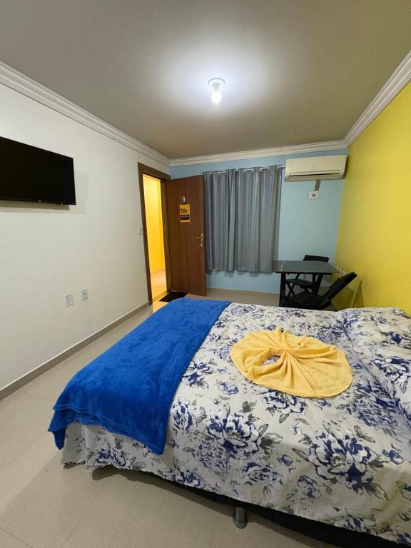- une chambre avec un lit et une serviette jaune dans l'établissement Quarto privado próximo ao centro, à Manaus