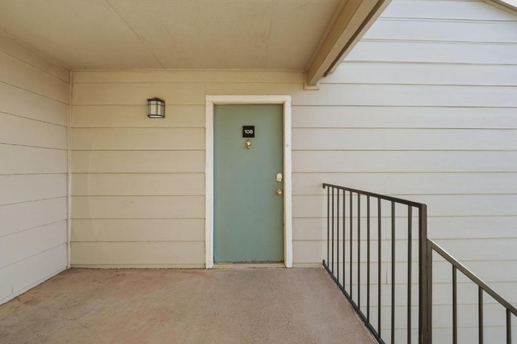una puerta azul en el lateral de una casa en District West Apartments Simple Modern Home, en Doud