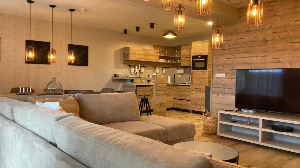 a living room with a couch and a flat screen tv at Apartments Panorama Donovaly in Donovaly