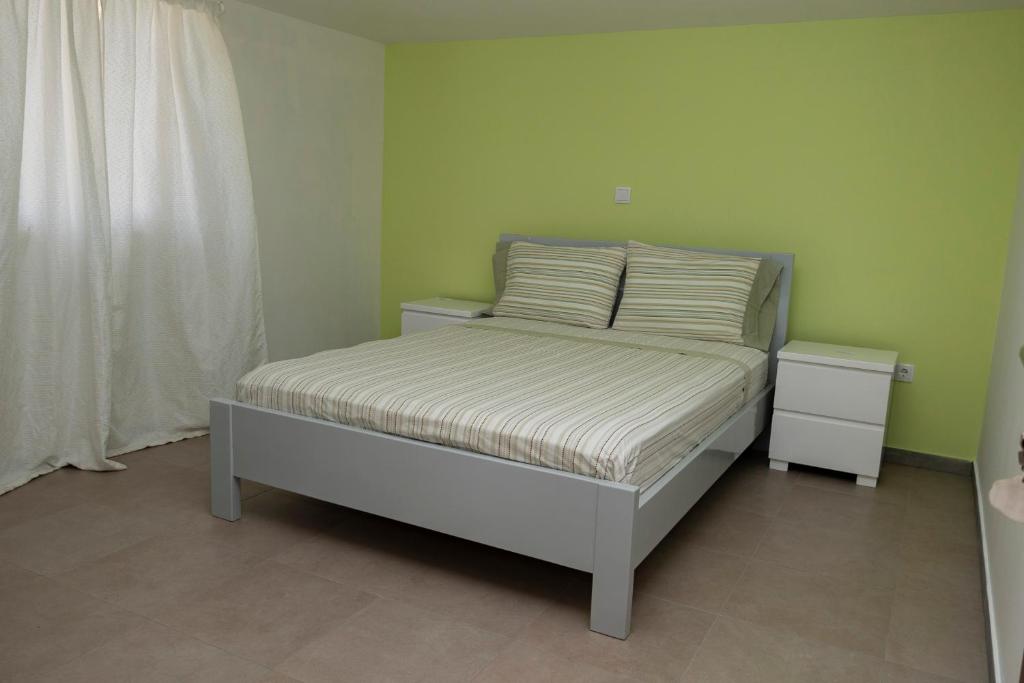 a bed with two pillows on it in a room at Quarto com Vista para a Cidade in Ribeira Grande