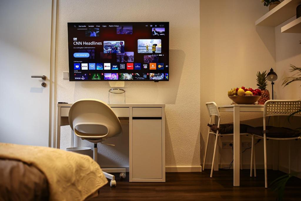 a room with a desk and a tv on a wall at Lumé26 in Koblenz