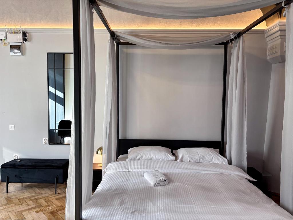 a white bed with a canopy in a bedroom at Moonlight City Center Studio-Private Parking, king in Cluj-Napoca