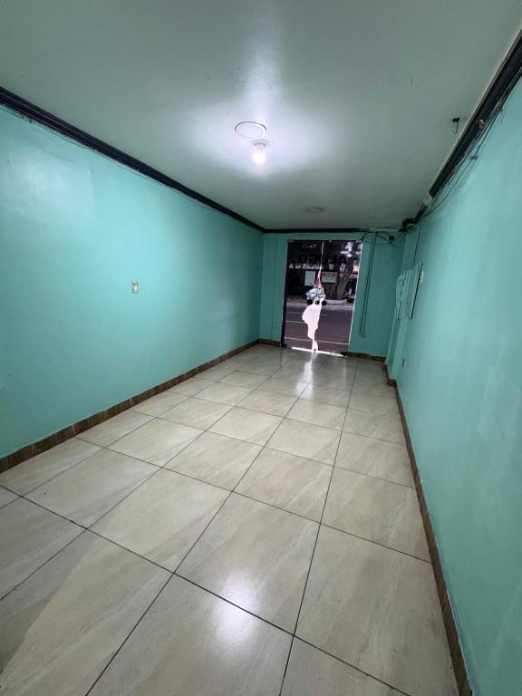 Una habitación vacía con paredes azules y suelo de baldosas. en Quarto privado no centro 313, en Manaus