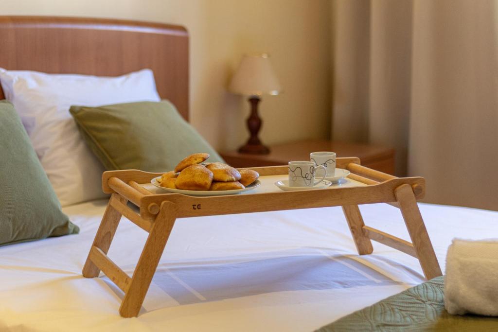 een dienblad met gebak op een tafel op een bed bij Gouveia Forest Guest House in Gouveia