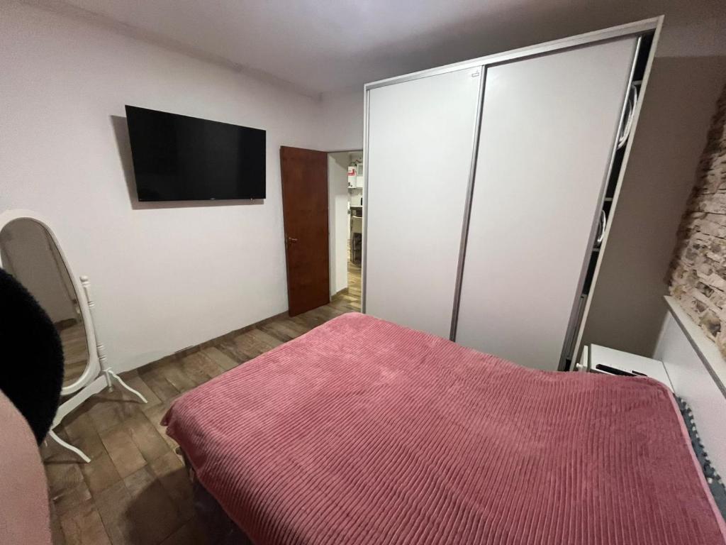 Un dormitorio con una cama y un televisor en una pared. en Alojamiento luxur, en San José