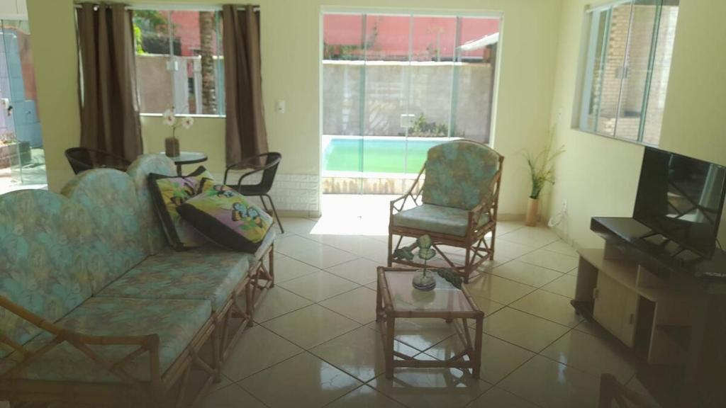 カボ・フリオにあるCasa para temporada em Cabo frioのリビングルーム(ソファ、椅子2脚、テレビ付)