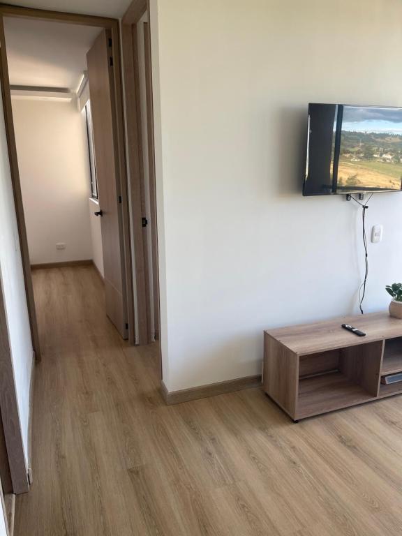 a living room with a flat screen tv on a wall at Apartamento completo cómodo con vista y todo cerca CC VIVA in Tunja