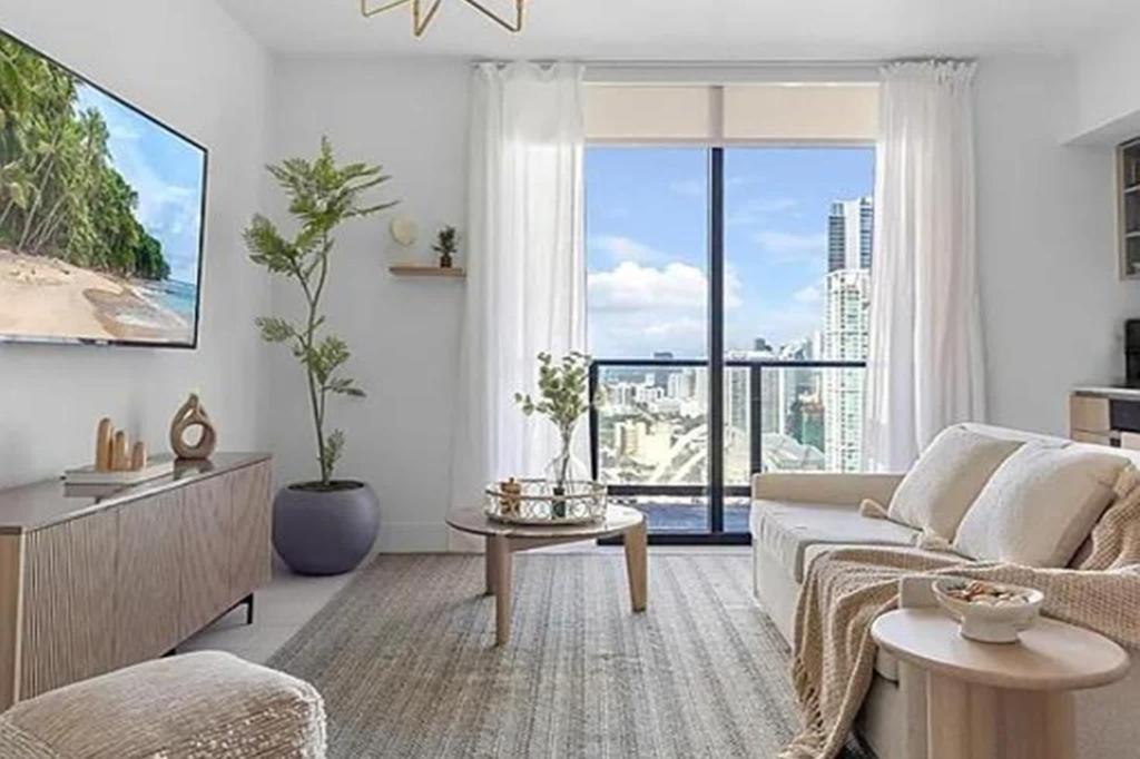 un salon avec un canapé et une grande fenêtre dans l'établissement Stylish High-Rise Corner Unit, à Miami