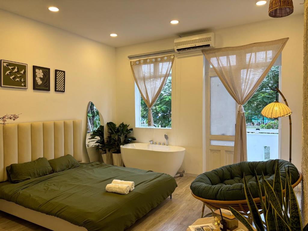 a bedroom with a bed and a tub and a sink at De'Lea Homestay & Hotel in Ho Chi Minh City