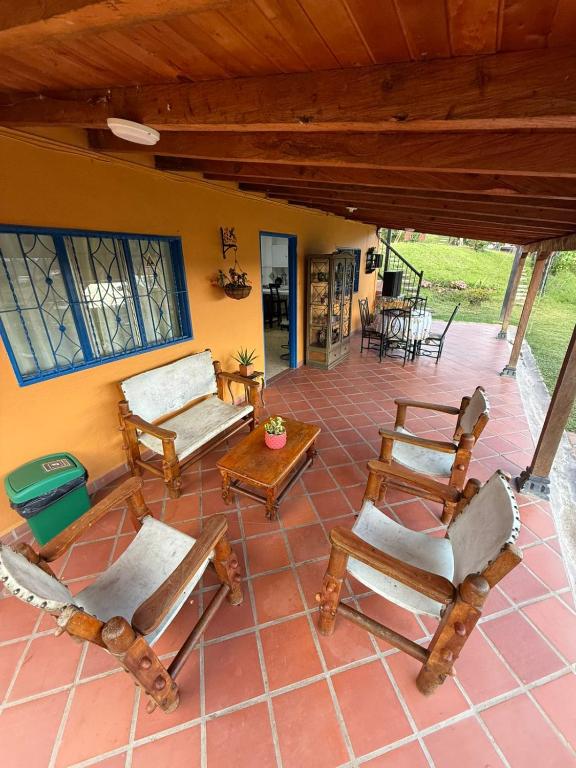 a patio with rocking chairs and a table at Encantadora finca en el corazón de Marinilla con vistas únicas y ubicación privilegiada in Marinilla