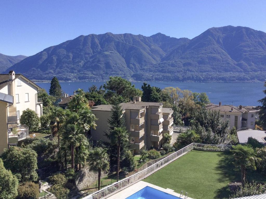 an aerial view of a apartment complex with a swimming pool and mountains at Bellavista by Fewotessin in Locarno