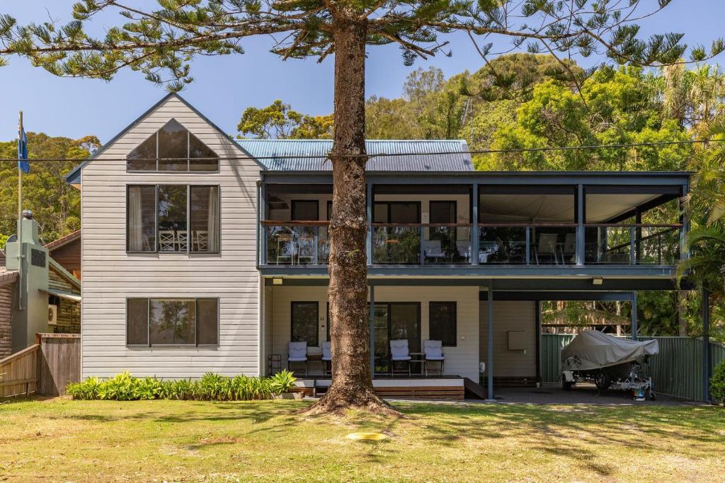 ein Haus mit einem Baum davor in der Unterkunft The Norfolk in Smiths Lake