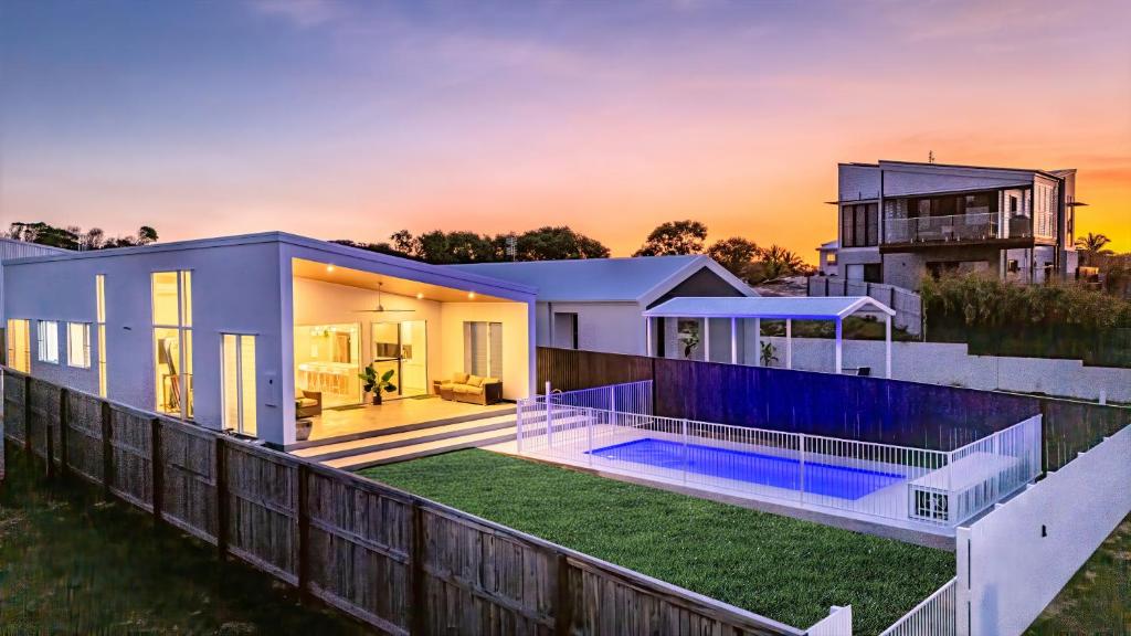 a house with a swimming pool in front of it at Sandy Soles in Agnes Water